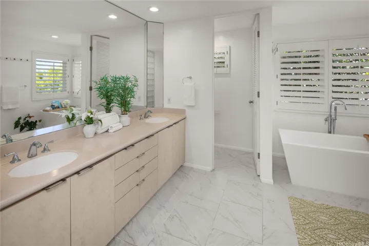 Primary bathroom offers a sleek design with both a deep soaking tub and a shower.