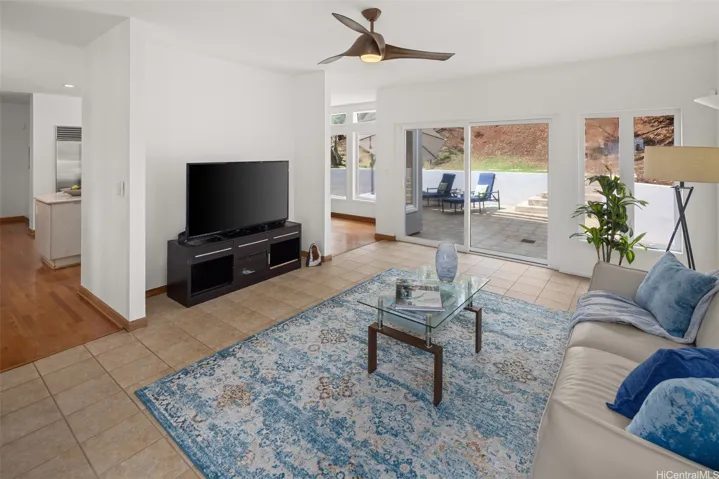 The entertainment room is adjacent to the kitchen and opens to both the back yard and the side yard.
