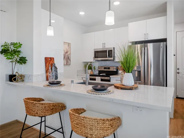 Spacious kitchen island showcases quartz countertops, a large single-basin stainless steel sink and sleek faucet perfect for meal prep, entertaining and everyday iiving.
