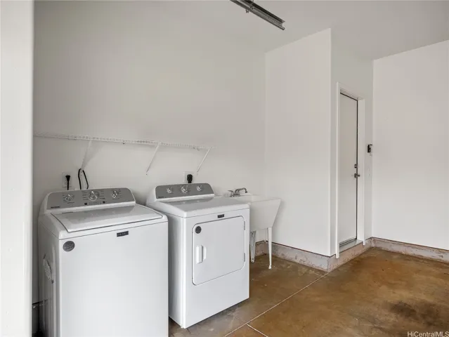 Convenient laundry area with utility sink in garage.  Washer and dryer included.