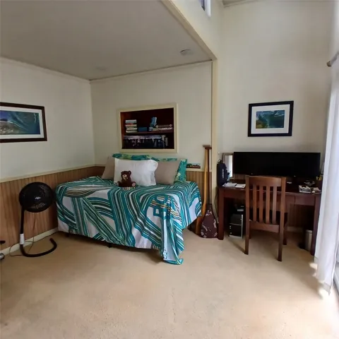 Bedroom 4 can fit a queen bed or smaller and has sliding glass doors opening to a side lanai.