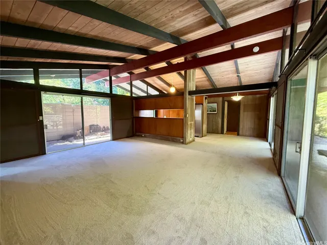 Spacious living area with high ceilings and brand-new carpet.