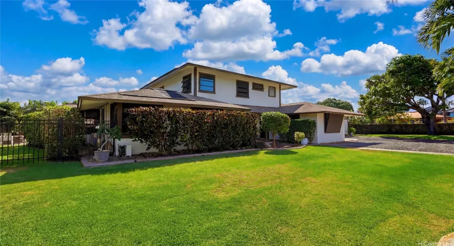 Beautifully manicured, spacious green lawn flanking the side of the two-story estate.