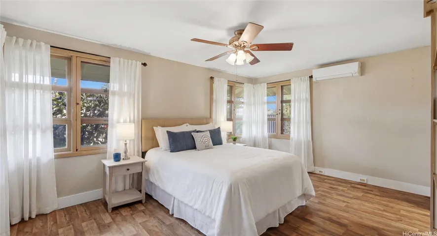 Bright main-level bedroom suite featuring split AC, a ceiling fan, and a private en-suite bath.