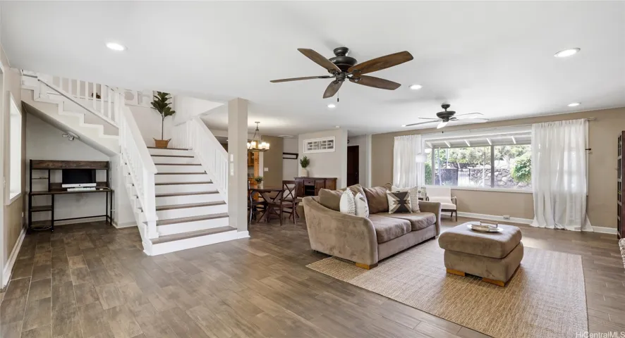 Bright living space showcasing a functional under-stair desk nook and seamless flow to the dining area.