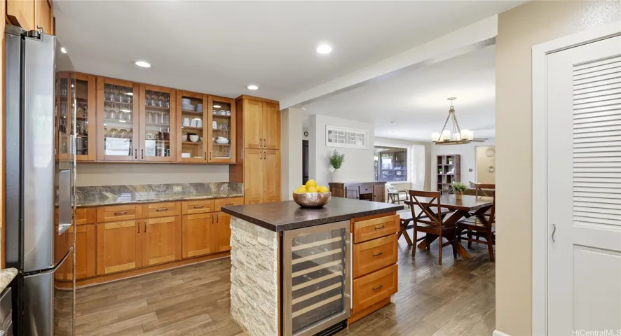 Functional kitchen layout highlighting extensive cabinetry, a built-in wine refrigerator, and seamless dining access.