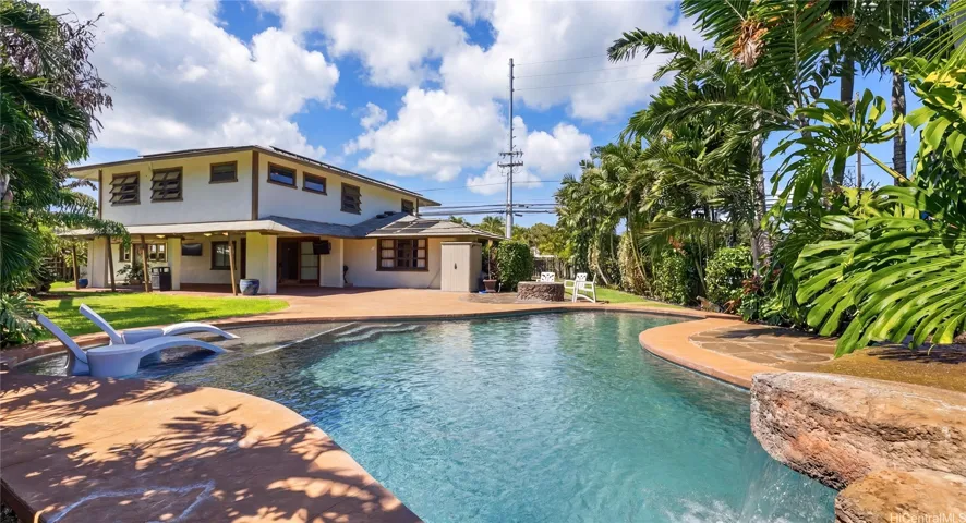 Massive backyard oasis boasting a custom pool, waterfall, and expansive patio space made for entertaining