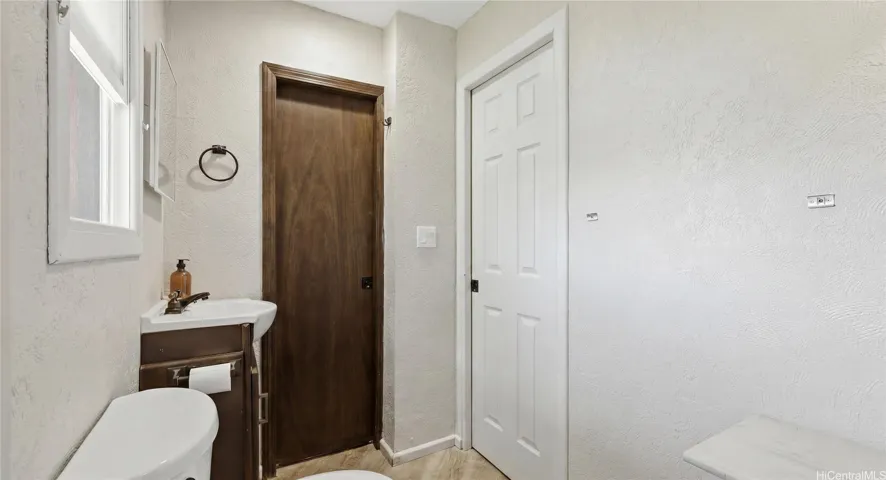 Full bathroom off the garage with direct backyard access, perfect for showering after swimming in the pool.