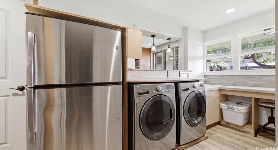 Dedicated laundry room featuring front-load appliances, folding counter, extra fridge, and integrated storage ideal for use as a pantry.