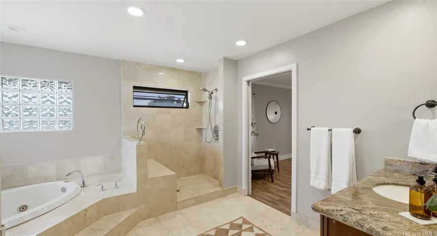 Luxury primary bath with a deep soaking tub, tiled walk-in shower with a built-in bench.