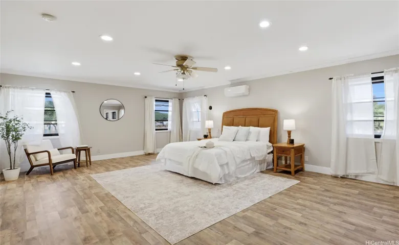 Spacious upstairs primary suite featuring split AC, a ceiling fan, and durable, modern flooring.