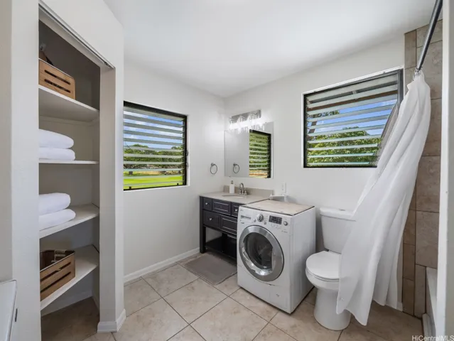 Primary full bathroom has a shower, large storage closet and 2 in 1 washer/dryer unit. Windows look out to the park and mountains