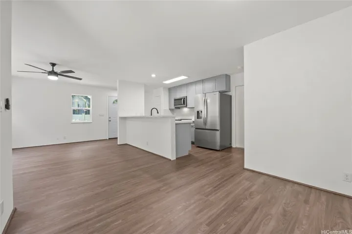 Open kitchen area with counter top seating and ample natural light