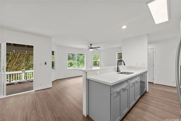 Open kitchen area with counter top seating and ample natural light