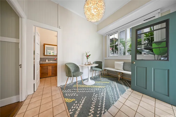 The breakfast area off of the dining room has original sliding windows and a door that leads out of the back of the front home.