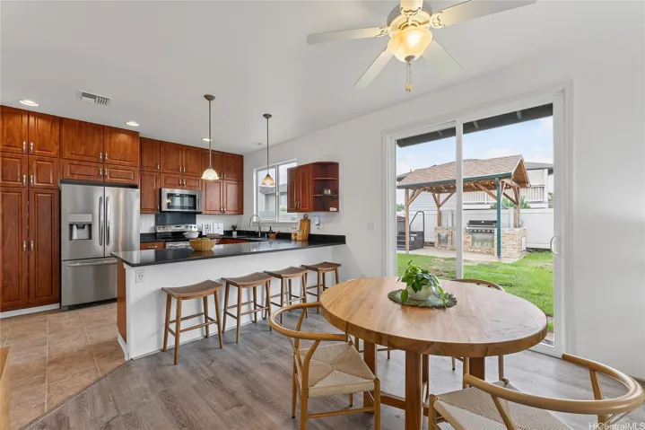 Casual dining area beside the kitchen, featuring a round table and backyard views.