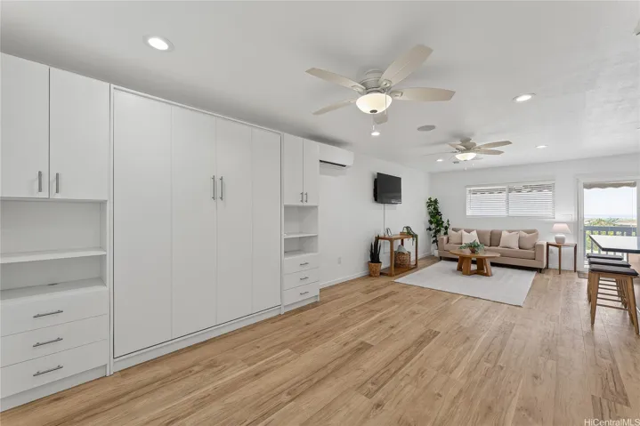 Second-floor living area with wood flooring, built-in storage, and plenty of room to relax.