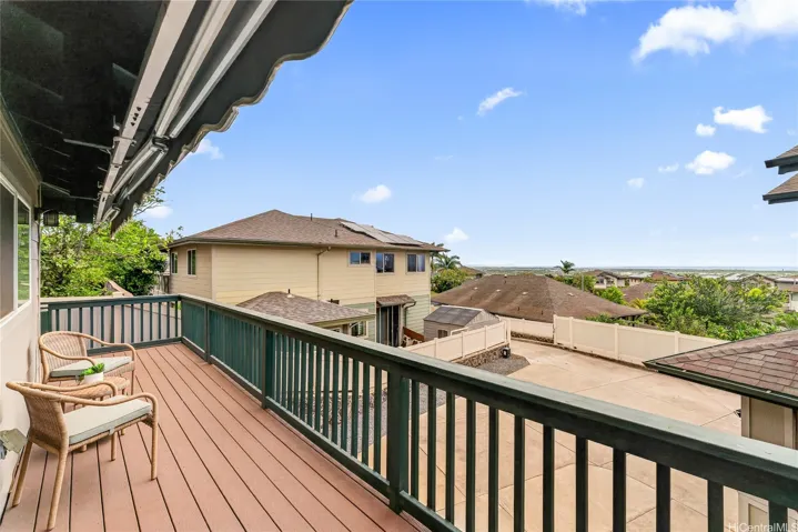Elevated outdoor deck with wood flooring, railing, and neighborhood views.