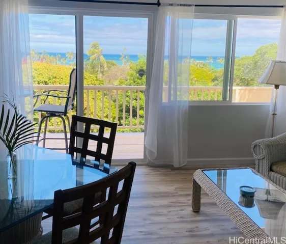 Living and dining area in downstairs area leads out to a lanai with ocean views.