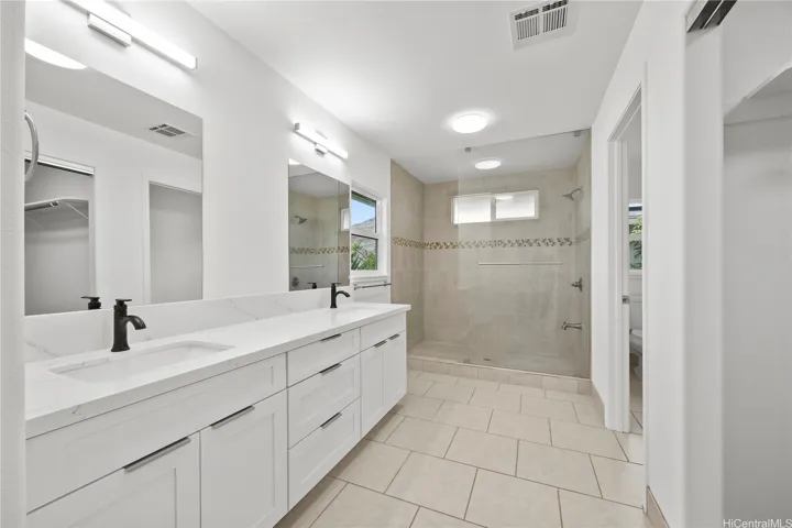 Primary bath with double sinks updated vanity & lighting with tiled shower