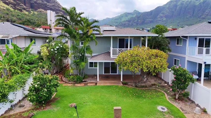 Rear exterior aerial view of the large open back yard and the two covered lanais which adorn this property