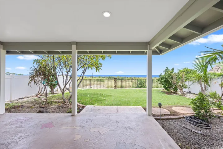 Large covered lanai with Hawaiian Islands imprint on the concrete floor and view of your spacious yard and ocean beyond
