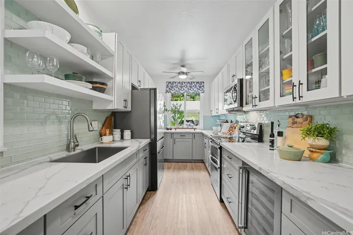 Gorgeous custom kitchen with quartz countertops, extended cabinetry, floating shelves, newer appliances including wine fridge, Samsung refrigerator with beverage center, and double oven with convection!