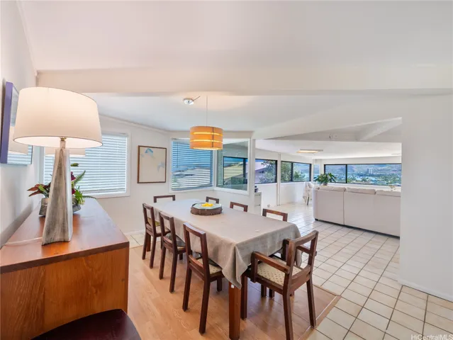 Dining area and den with big windows and tiled flooring.