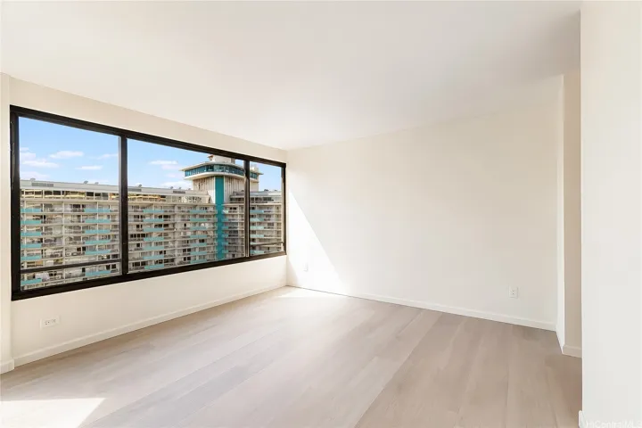 Primary bedroom with floor-to-ceiling windows and peaceful Waikiki views