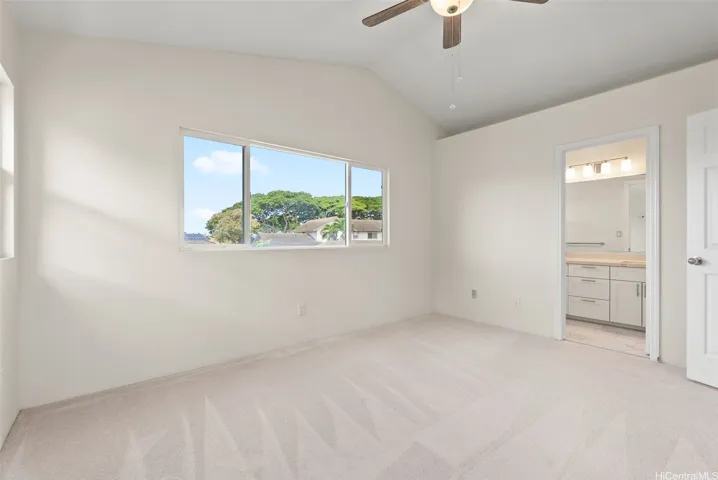 Ensuite Primary bedroom with vaulted ceilings.