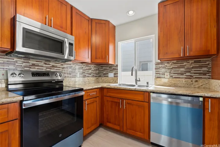 Kitchen with brand new stainless steel appliances.