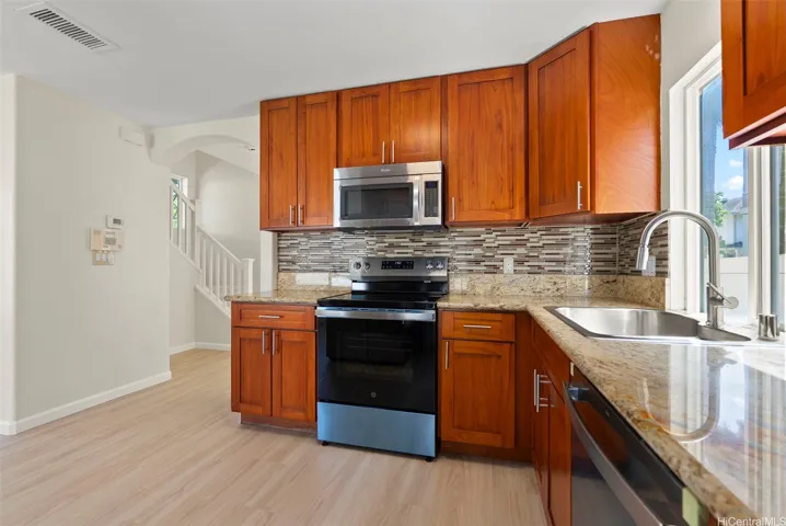 Kitchen with granite countertops & modern wood cabinetry.
