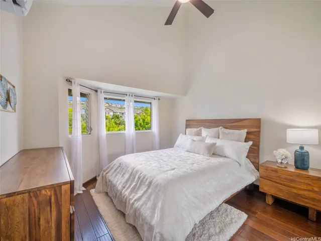 Second bedroom with high ceilings and leafy views, thoughtfully separated from the primary suite for added privacy.