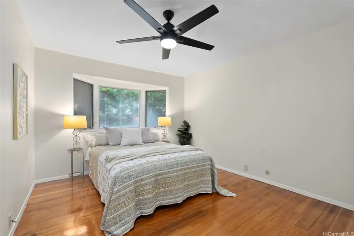 Comfortable bedroom 1 of 4 on the main level with bay window, ceiling fan, and soft natural light.