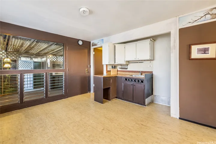 Living area of separate one bedroom with sink and cabinets.