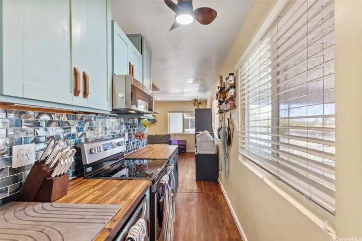 Cohesive colors and custom wooden drawer and cabinet pulls. Wooden Storage inset helps create space.  Opens toward the living area, great for cooking and meal prepping!