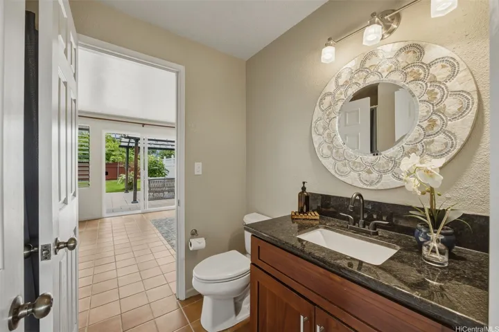 One of two main level full bathrooms is a pass-through conveniently located adjacent to the kitchen and family room on one side and the den/bedroom on the other side, and just a few steps from the back door for quick clean up when returning from the beach.