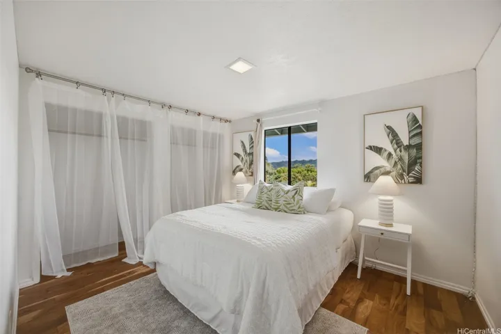 Third upstairs bedroom with engineered hardwood flooring, large closet, and tropical views.
