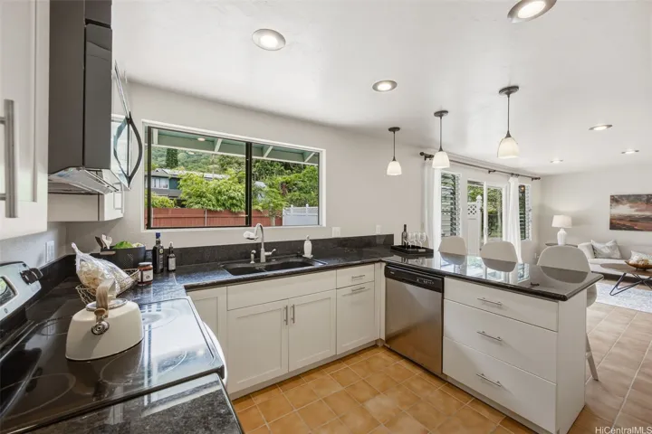Updated kitchen with quartz counters, shaker style wood cabinets, stainless steel appliances, and backyard &
Koolau views. Large family room or dining area just beyond.