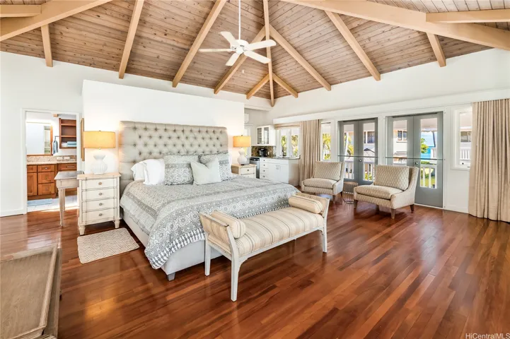 Spectacular primary bedroom suite w/wet bar, French doors that open to wraparound lanai and rooftop deck.