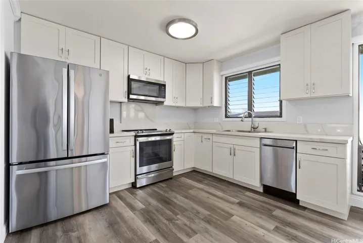 Renovated kitchen with quartz counters and stainless steel appliances