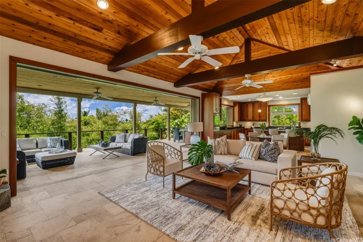 The great room features vaulted open wood ceilings and built-in book shelves and entertainment center. The custom 24' mahogany sliders open fully to bring the outdoors in.