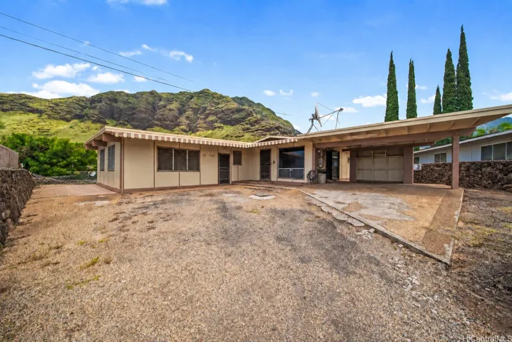 Front exterior with a mountain backdrop and open yard.