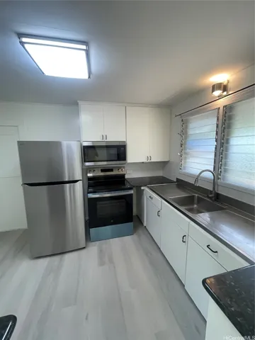 KITCHEN AREA WITH SINK,  STOVE, MICROWAVE AND REFRIGERATOR