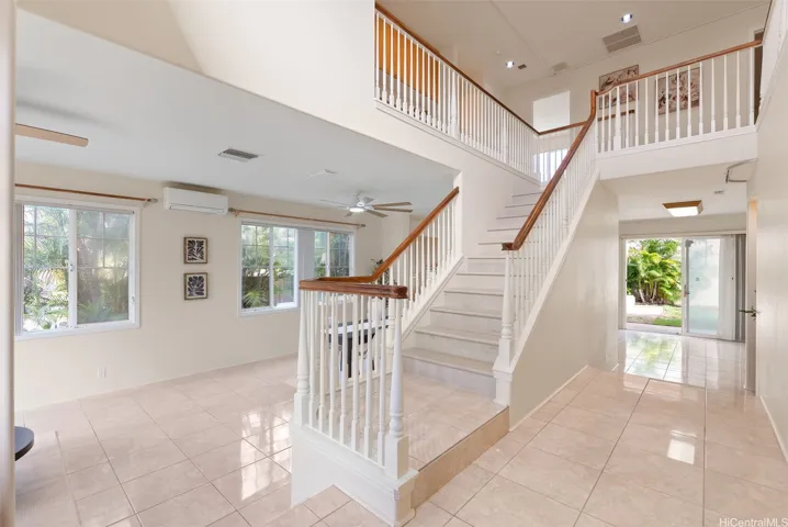 The entry opens to the main living area and staircase leading to the second floor.