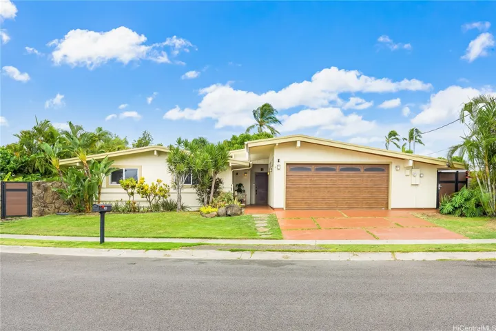 Charming curb appeal with rock wall and side gates.