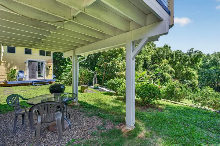Downstairs grill/covered lanai area looking towards the detached cottage on the left and flowing to the gardens on the right.