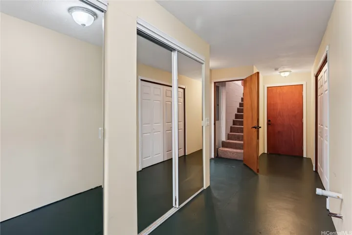 Stairwell from upstairs flows to downstairs flexible living spaces.  Closed door leads to a bedroom, bath, and wetbar currently occupied as tenant space with a separate exterior entrance.  To the right is one of two additional plumbing stub outs for downstairs spaces. Lots of storage!