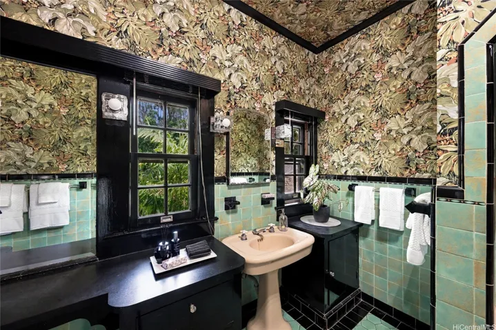 This bathroom is on the main level and features a double vanity and original tile.