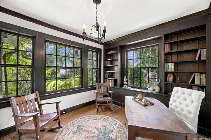 A picturesque study with built-in bookshelves looks onto the sprawling front yard.